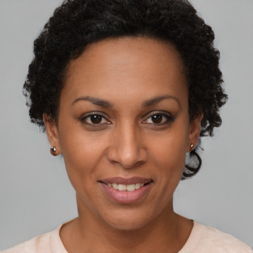 Joyful black young-adult female with short  brown hair and brown eyes