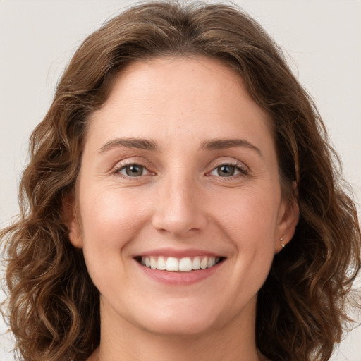 Joyful white young-adult female with long  brown hair and green eyes