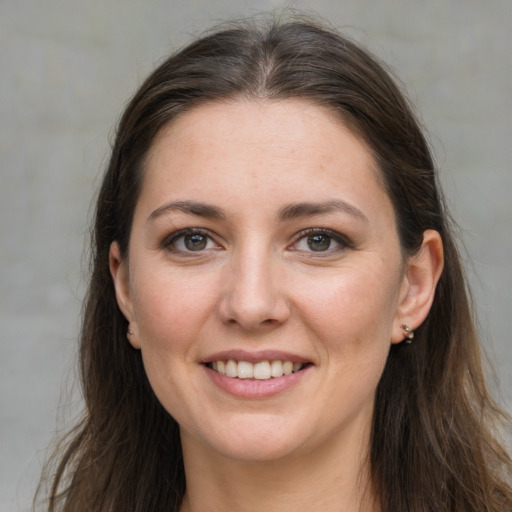 Joyful white young-adult female with long  brown hair and grey eyes