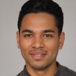 Joyful latino young-adult male with short  brown hair and brown eyes