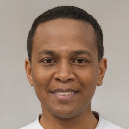 Joyful black young-adult male with short  black hair and brown eyes