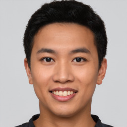 Joyful asian young-adult male with short  black hair and brown eyes