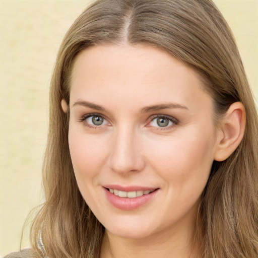 Joyful white young-adult female with long  brown hair and green eyes