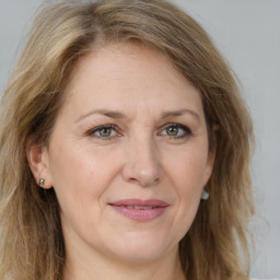 Joyful white adult female with long  brown hair and green eyes