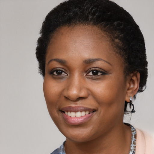Joyful black young-adult female with short  black hair and brown eyes