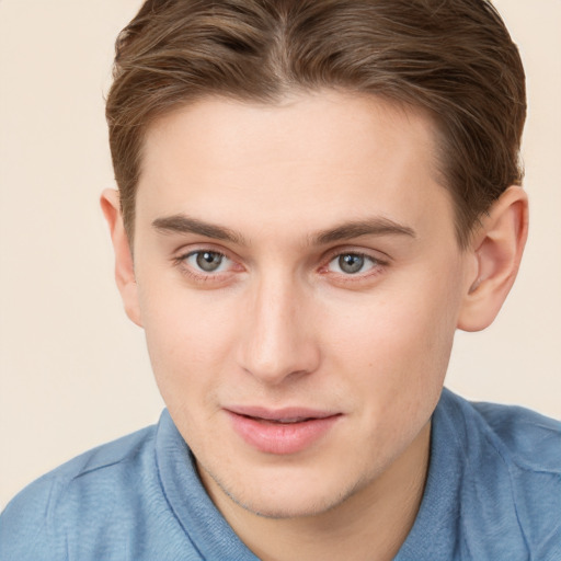 Joyful white young-adult male with short  brown hair and grey eyes