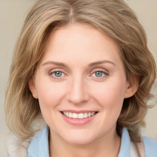 Joyful white young-adult female with medium  brown hair and blue eyes