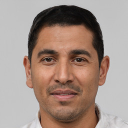 Joyful white adult male with short  black hair and brown eyes