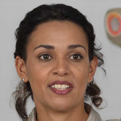 Joyful latino adult female with medium  brown hair and brown eyes