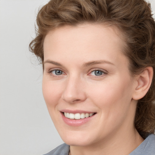 Joyful white young-adult female with medium  brown hair and blue eyes