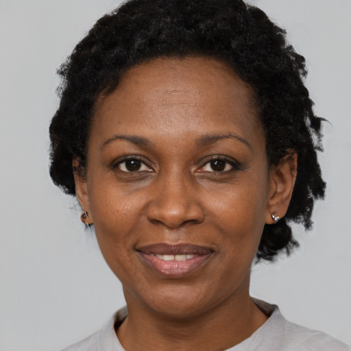 Joyful black adult female with short  black hair and brown eyes