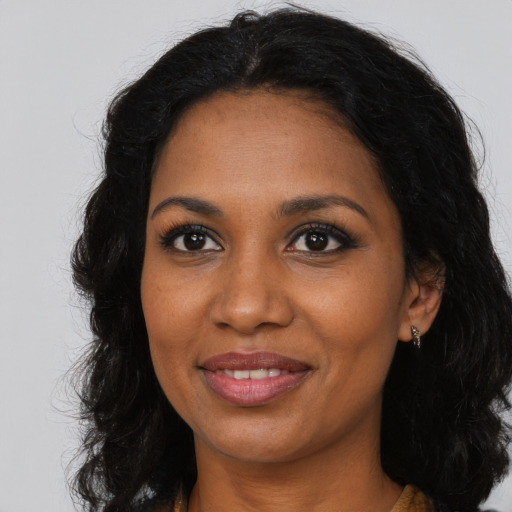 Joyful black young-adult female with long  brown hair and brown eyes