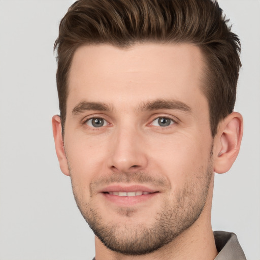 Joyful white young-adult male with short  brown hair and grey eyes