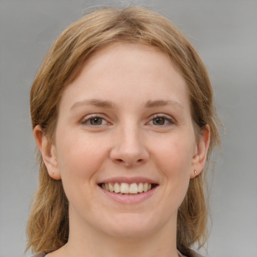 Joyful white young-adult female with medium  brown hair and grey eyes