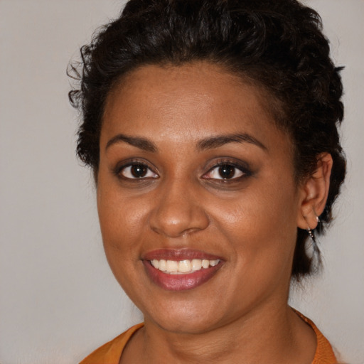 Joyful black young-adult female with medium  brown hair and brown eyes