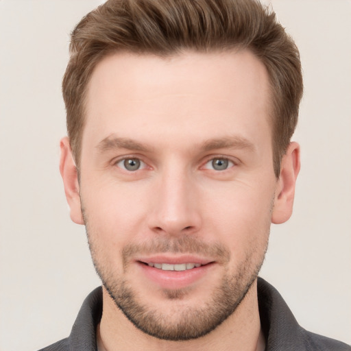 Joyful white young-adult male with short  brown hair and grey eyes