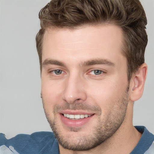 Joyful white young-adult male with short  brown hair and blue eyes