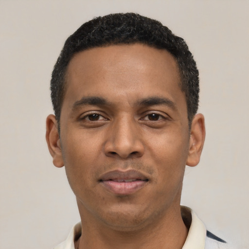 Joyful black young-adult male with short  black hair and brown eyes