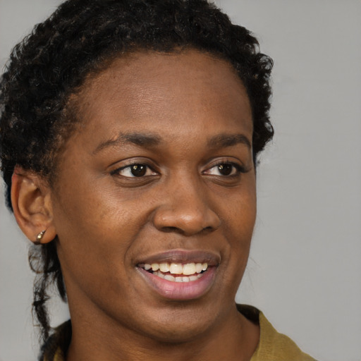 Joyful black young-adult female with short  brown hair and brown eyes