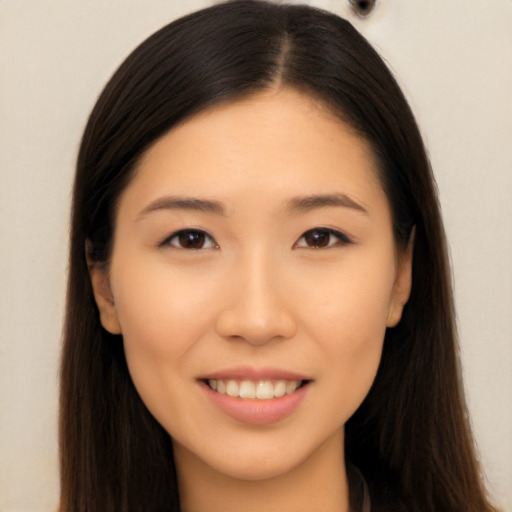 Joyful asian young-adult female with long  brown hair and brown eyes