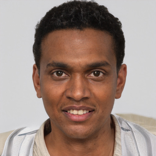 Joyful black young-adult male with short  black hair and brown eyes