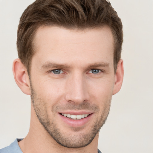 Joyful white young-adult male with short  brown hair and grey eyes