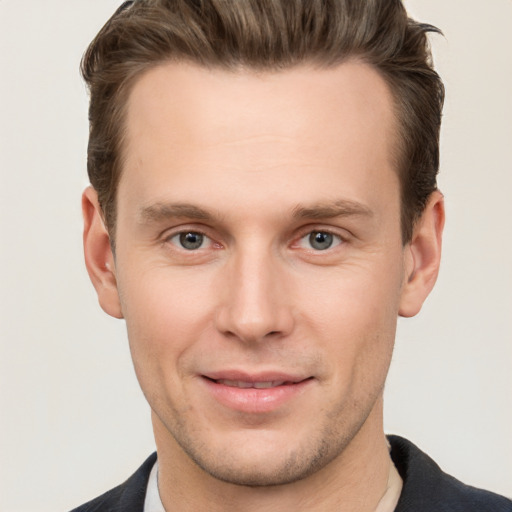 Joyful white young-adult male with short  brown hair and grey eyes