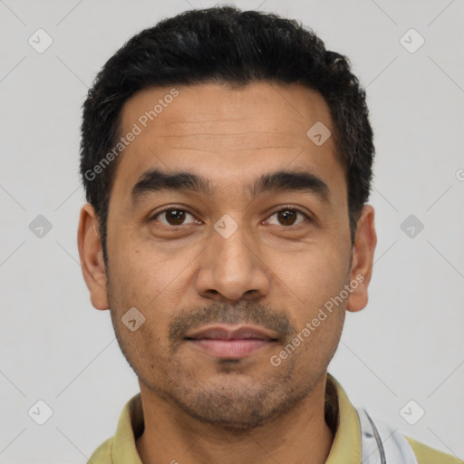 Joyful latino young-adult male with short  black hair and brown eyes