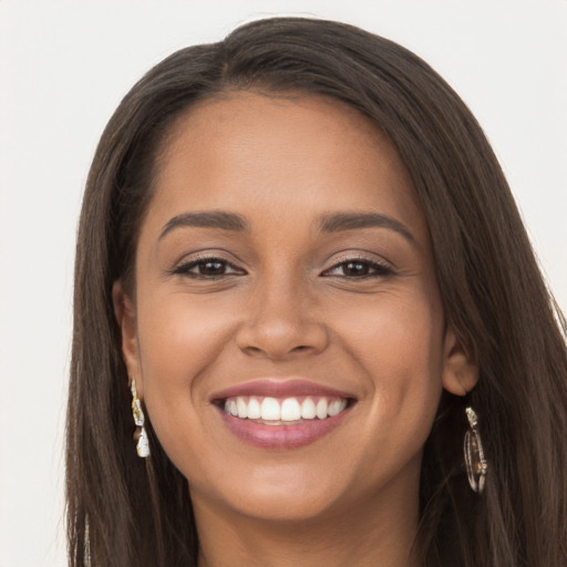 Joyful latino young-adult female with long  brown hair and brown eyes