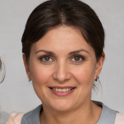 Joyful white adult female with medium  brown hair and brown eyes