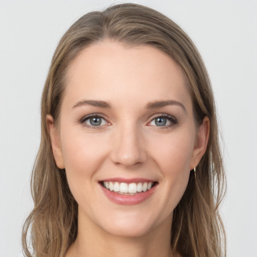 Joyful white young-adult female with long  brown hair and blue eyes