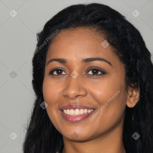 Joyful black young-adult female with long  black hair and brown eyes