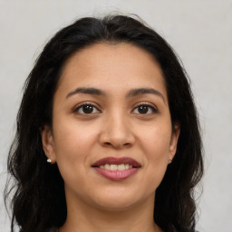 Joyful latino young-adult female with long  brown hair and brown eyes