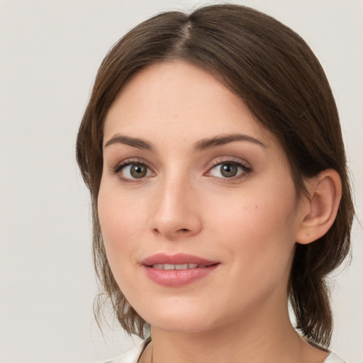 Joyful white young-adult female with medium  brown hair and green eyes