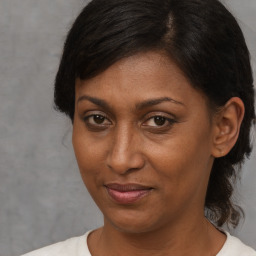 Joyful black adult female with medium  brown hair and brown eyes