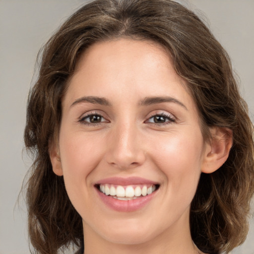 Joyful white young-adult female with medium  brown hair and green eyes