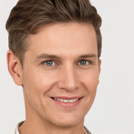 Joyful white young-adult male with short  brown hair and grey eyes