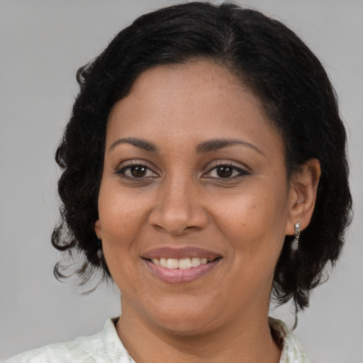 Joyful latino adult female with medium  brown hair and brown eyes