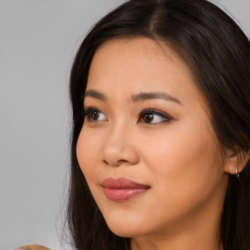 Joyful asian young-adult female with long  brown hair and brown eyes