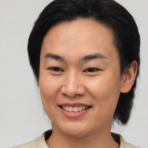 Joyful asian young-adult female with medium  brown hair and brown eyes