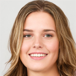 Joyful white young-adult female with long  brown hair and green eyes