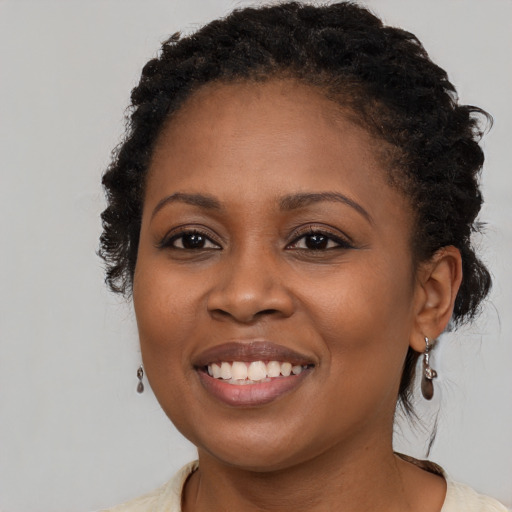 Joyful black young-adult female with long  brown hair and brown eyes