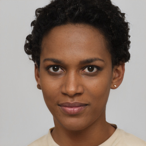 Joyful black young-adult female with short  black hair and brown eyes