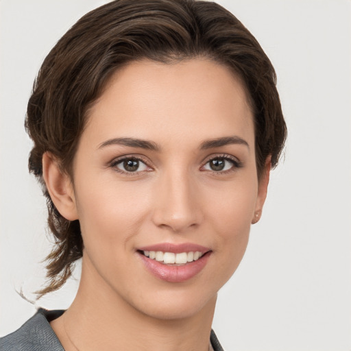 Joyful white young-adult female with medium  brown hair and grey eyes