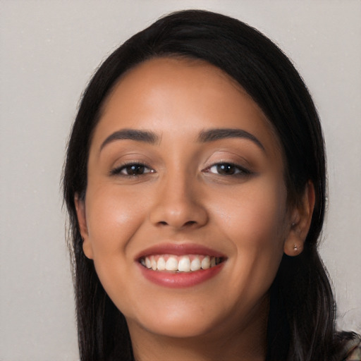 Joyful latino young-adult female with long  black hair and brown eyes