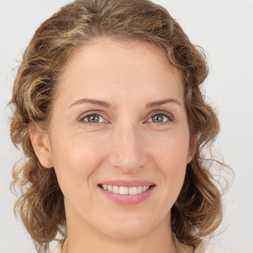 Joyful white young-adult female with medium  brown hair and green eyes