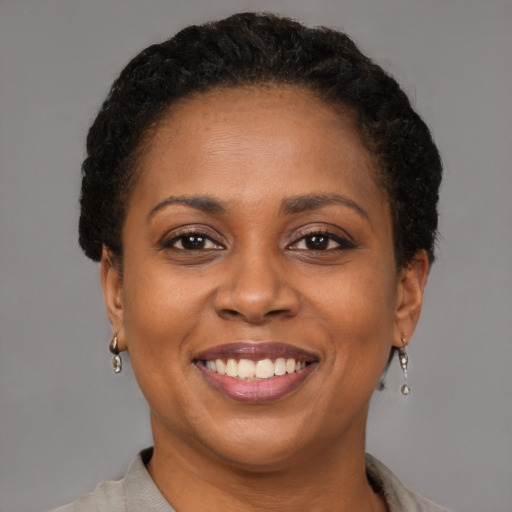 Joyful black adult female with short  brown hair and brown eyes