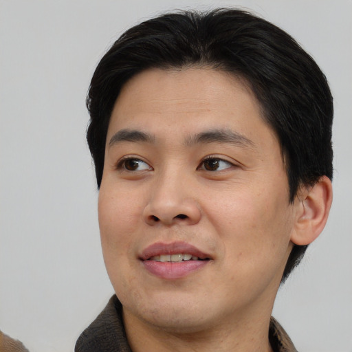 Joyful asian young-adult male with short  brown hair and brown eyes