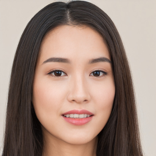 Joyful asian young-adult female with long  brown hair and brown eyes