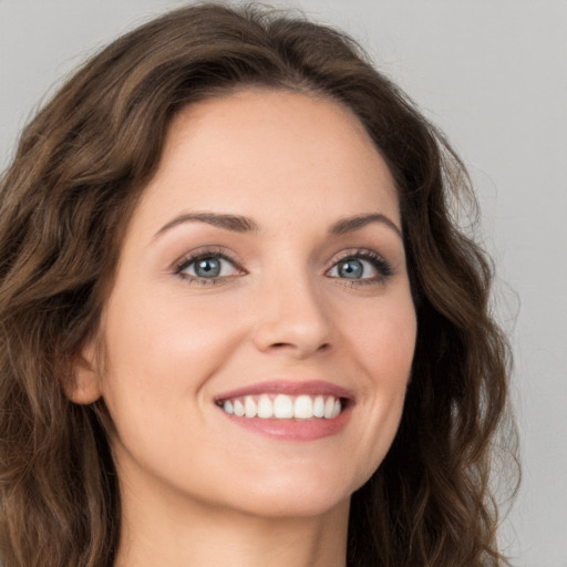 Joyful white young-adult female with long  brown hair and green eyes